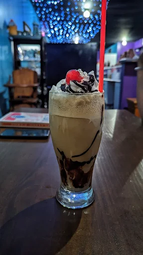 Tall glass soda float with whipped cream and a cherry