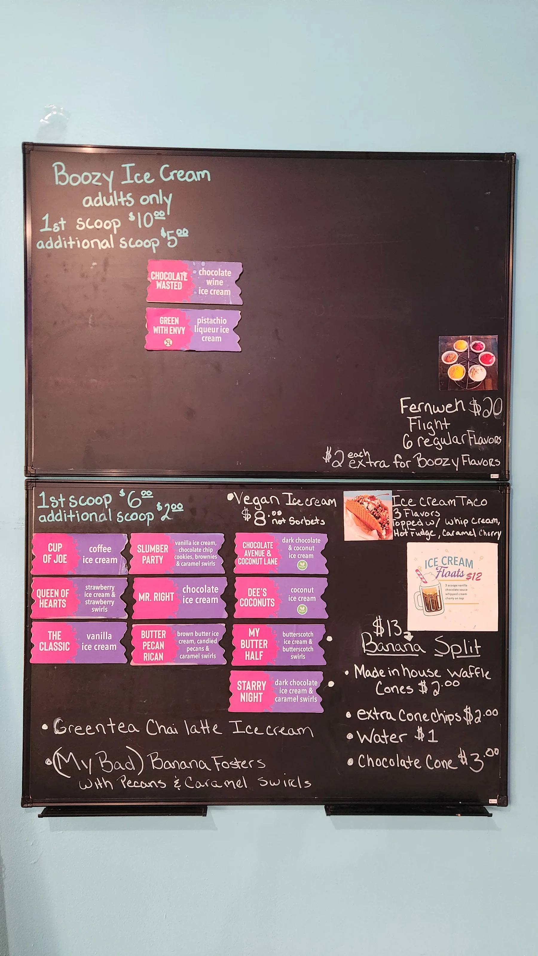 Hand-written chalkboard menu listing this week's flavors, boozy options, vegan ice creams, the Fernweh Flight, banana split, and prices