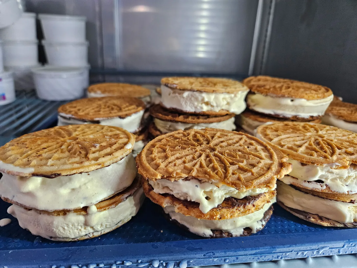 Stacks of pizzelle ice cream sandwiches — vanilla ice cream pressed between two golden pizzelles